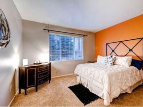 Aurora apartment for rent - A bedroom with a white bed and a black rug.