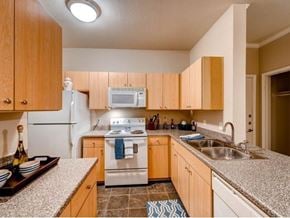 Aurora apartment for rent - A kitchen with wooden cabinets and a white refrigerator.