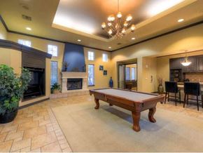 Aurora apartment for rent - A pool table is in the middle of a room with a fireplace and a chair.
