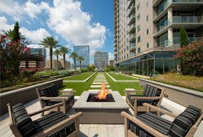Houston apartment for rent - an outdoor lounge area with a fire pit in front of an apartment building