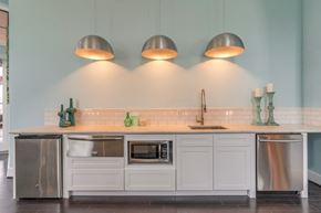 Spring apartment for rent - a kitchen with white cabinets and stainless steel appliances
