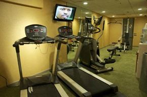 Cleveland apartment for rent - a gym with several machines and a television on the wall