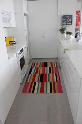 Cleveland apartment for rent - a kitchen with white cabinets and a rug on the floor