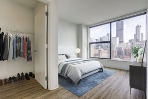 Chicago apartment for rent - a bedroom with a bed and a large window