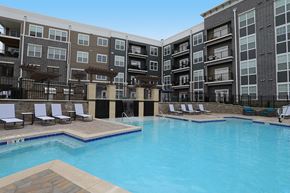 Centerville apartment for rent - a swimming pool with lounge chairs in front of an apartment building