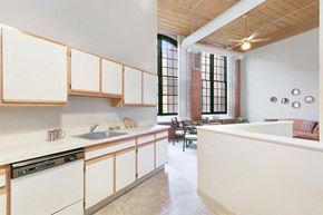 Manchester apartment for rent - an empty kitchen with white cabinets and a large window