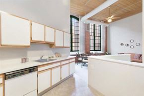 Manchester apartment for rent - an empty kitchen with white cabinets and a large window