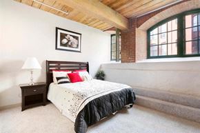 Manchester apartment for rent - a bedroom with a bed and a brick wall