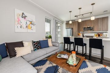 Denver apartment for rent - A living room with a grey couch and a coffee table with a glass top.