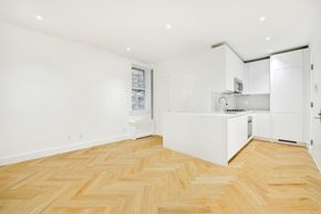 Brooklyn apartment for rent - a kitchen with white cabinets and a wood floor