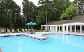 Stone Mountain apartment for rent - A swimming pool with a blue umbrella and chairs around it.