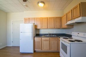 Missoula apartment for rent - a kitchen with white appliances and wooden cabinets