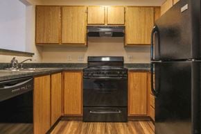 Missoula apartment for rent - a kitchen with black appliances and wooden cabinets