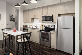 Chamblee apartment for rent - a kitchen with stainless steel appliances and a white table and chairs