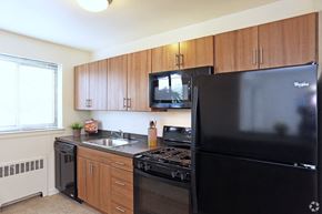 Lancaster apartment for rent - a kitchen with black appliances and wooden cabinets