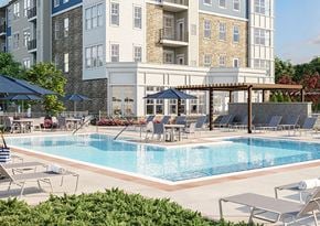 Willow Grove apartment for rent - a swimming pool with chairs and umbrellas in front of a building