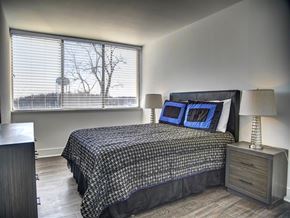 Annapolis apartment for rent - A bedroom with a large bed and a window with blinds.