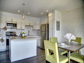Annapolis apartment for rent - A kitchen with a table set for two with green chairs.