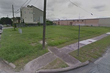 Houston apartment for rent - A grassy area with a sidewalk and a building in the background.