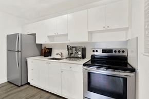 N. Miami apartment for rent - A modern kitchen with a stainless steel oven and white cabinets.