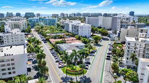 Bay Harbor Islands apartment for rent - A cityscape with buildings, cars, and palm trees.