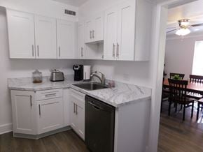Shaker Heights apartment for rent - a kitchen with white cabinets and a sink and a table
