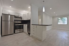 Miami apartment for rent - a kitchen with stainless steel appliances and white cabinets