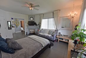 Miami Beach apartment for rent - a bedroom with a bed and a living room with a fireplace
