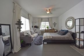 Miami Beach apartment for rent - a bedroom with a couch and a bed and a ceiling fan