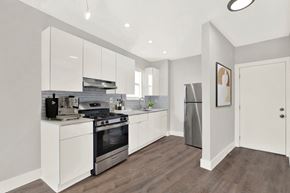 N.Bay Village apartment for rent - A modern kitchen with white cabinets and stainless steel appliances.