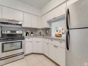 Hialeah apartment for rent - A modern kitchen with white cabinets and a stainless steel refrigerator.