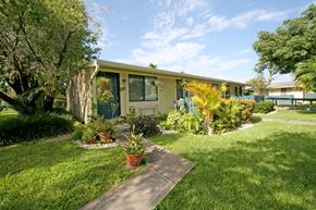 Homestead apartment for rent - a house with a lawn and potted plants in front of it