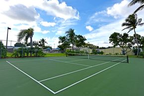Homestead apartment for rent - a tennis court with palm trees and a fence around it
