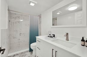 Lake Worth apartment for rent - A white bathroom with a marble shower and a white sink.