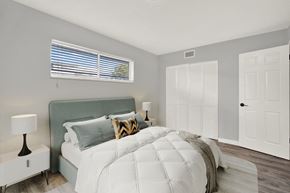 Lake Worth apartment for rent - A bedroom with a large bed and a window with blinds.