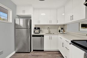 Lake Worth apartment for rent - A modern kitchen with white cabinets and stainless steel appliances.