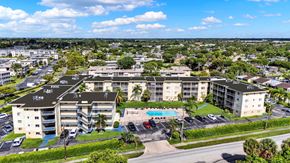 Lake Worth apartment for rent - A large apartment complex with a pool in the middle of a parking lot.