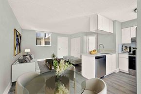 Miami Beach apartment for rent - A modern kitchen with a glass table and white cabinets.