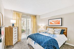 Lakewood apartment for rent - Master bedroom with bed and tall dresser with sliding patio doors