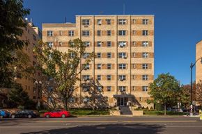 Washington apartment for rent - A tall building with a red car parked in front of it.