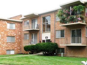 Herndon apartment for rent - a brick apartment building with balconies and a lawn