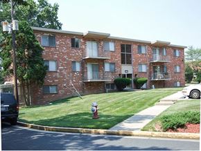 Herndon apartment for rent - a red brick apartment building with a fire hydrant in the grass
