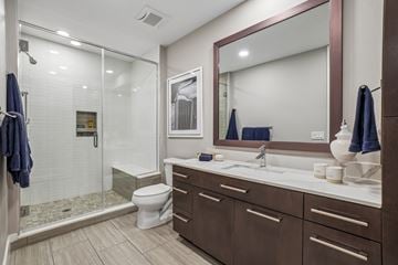 Denver apartment for rent - A bathroom with a toilet, sink, and mirror.