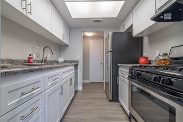 Riverside apartment for rent - A kitchen with white cabinets and a black refrigerator.