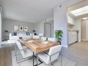 Riverside apartment for rent - A modern dining room with a wooden table and white chairs.