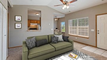 Eudora apartment for rent - a living room with a green couch and a ceiling fan