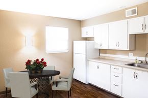 Lee's Summit apartment for rent - a kitchen with white cabinets and a table with chairs