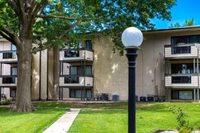 Lee's Summit apartment for rent - exterior view of a building with a tree and a lamp post