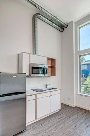 Seattle apartment for rent - a kitchen with white cabinets and stainless steel appliances and a window