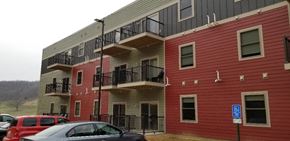 Richland Center apartment for rent - a red and white building with cars parked in front of it